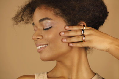 Close-up of young woman looking away against wall