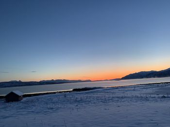 Scenic view of frozen lake against sky during sunset