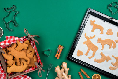 Top view of christmas gingerbread cookies from raw dough on baking tray, ginger, cinnamon,