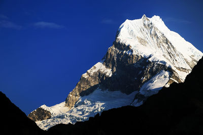 Low angle view of snow covered mountain against clear sky