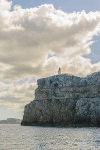 Rock formations by sea against sky