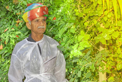   farmer stands in the garden with a colored turban tied on his head as per rajasthani hindu tradition