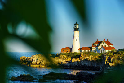 Lighthouse on shore against sky