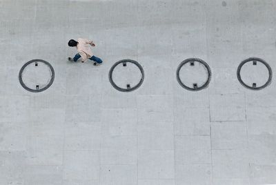 High angle view of man walking by manholes on street