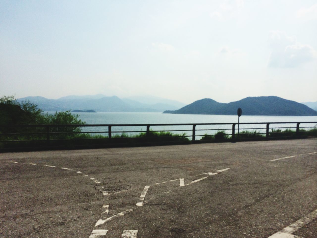 mountain, water, tranquil scene, tranquility, sky, scenics, mountain range, road, nature, beauty in nature, empty, railing, river, day, outdoors, the way forward, sea, landscape, clear sky, lake