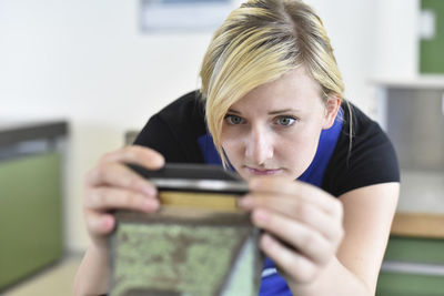 Female trainee examining workpiece in bench vice