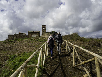 People walking on staircase against sky