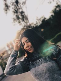 Young woman with hand in hair standing outdoors