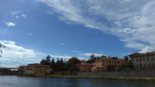 River by buildings against sky