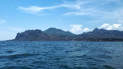 Scenic view of sea and mountains against sky