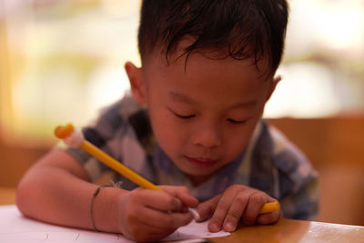 Cute boy writing on paper