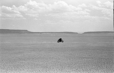 Scenic view of people on sea against sky