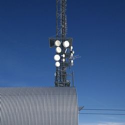 Low angle view of communications tower against clear blue sky