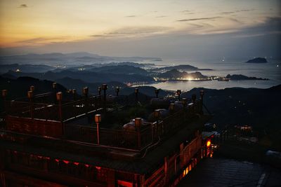 High angle view of illuminated city against sky during sunset