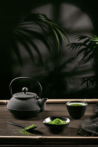 Matcha tea powder and tea accessories on dark wooden base. tea ceremony. vertical format.
