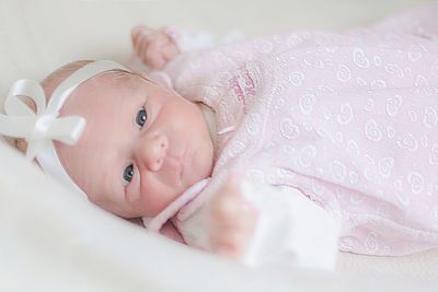 Portrait of cute baby girl lying on sofa