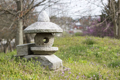 Stone lantern on field at cemetery