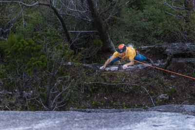 Man rock climbing in the woods to ledge top rope squamish chief