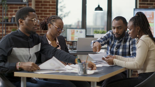 Businessman with colleagues discussing at desk in office