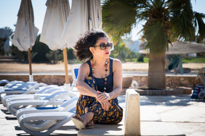 Young woman wearing sunglasses sitting outdoors