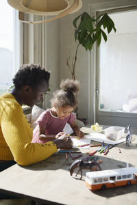 Mother and daughter drawing together