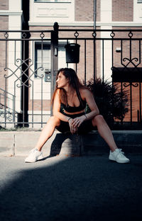 Young woman sitting in city