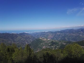 Scenic view of mountains against blue sky