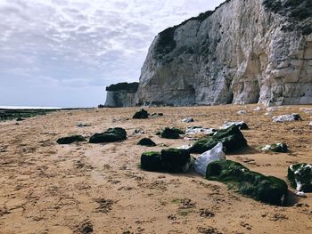 Rock formations on beach against sky