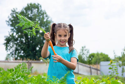 Portrait of girl holding plant