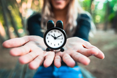 Close-up of woman hand holding clock