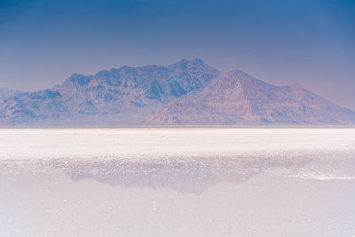 Mountain range reflected on salt flats in utah