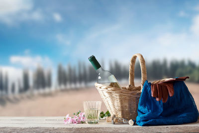 Close-up of wicker basket on table against blue sky