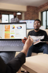 Midsection of woman using laptop at office