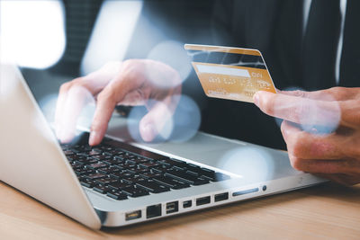 Midsection of man using laptop on table