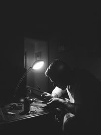 Man sitting in illuminated lamp