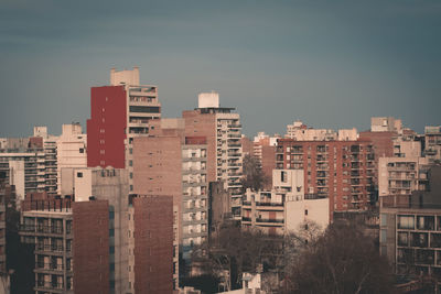 Buildings in city against clear sky