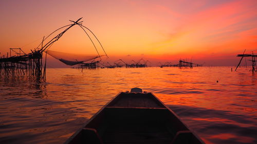 Silhouette sailboats in sea against sky during sunrise 