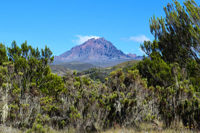 Scenic view of mountains against blue sky