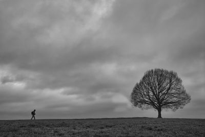 Silhouette person standing on field against sky