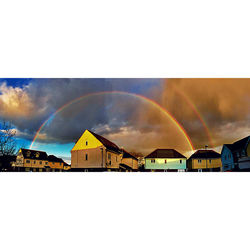 Rainbow over buildings against sky