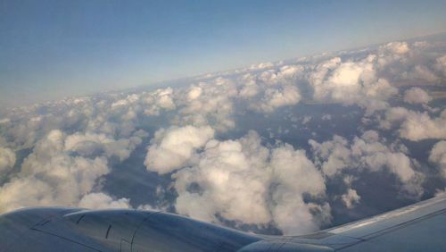 Aerial view of aircraft wing over clouds