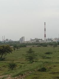 Factory on field against sky