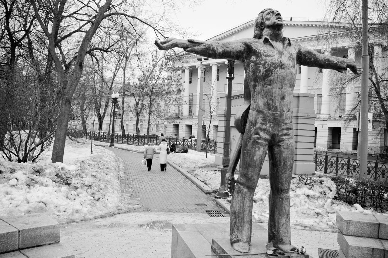 STATUE OF BARE TREE AGAINST BUILDING