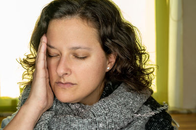 Close-up portrait of a serious young woman with eyes closed