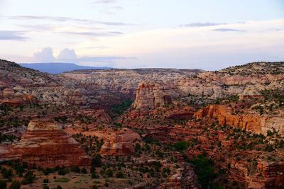 Rock formations on landscape against cloudy sky