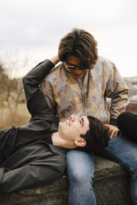 Male friends talking with each other on retaining wall