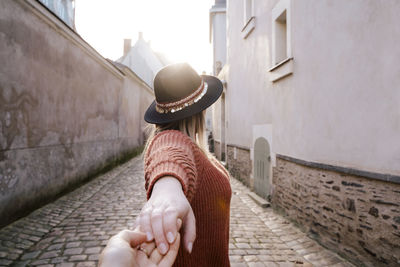 Woman holding hand in alley