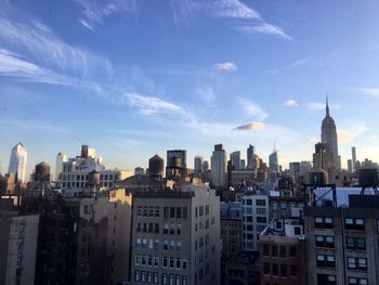 Buildings in city against cloudy sky