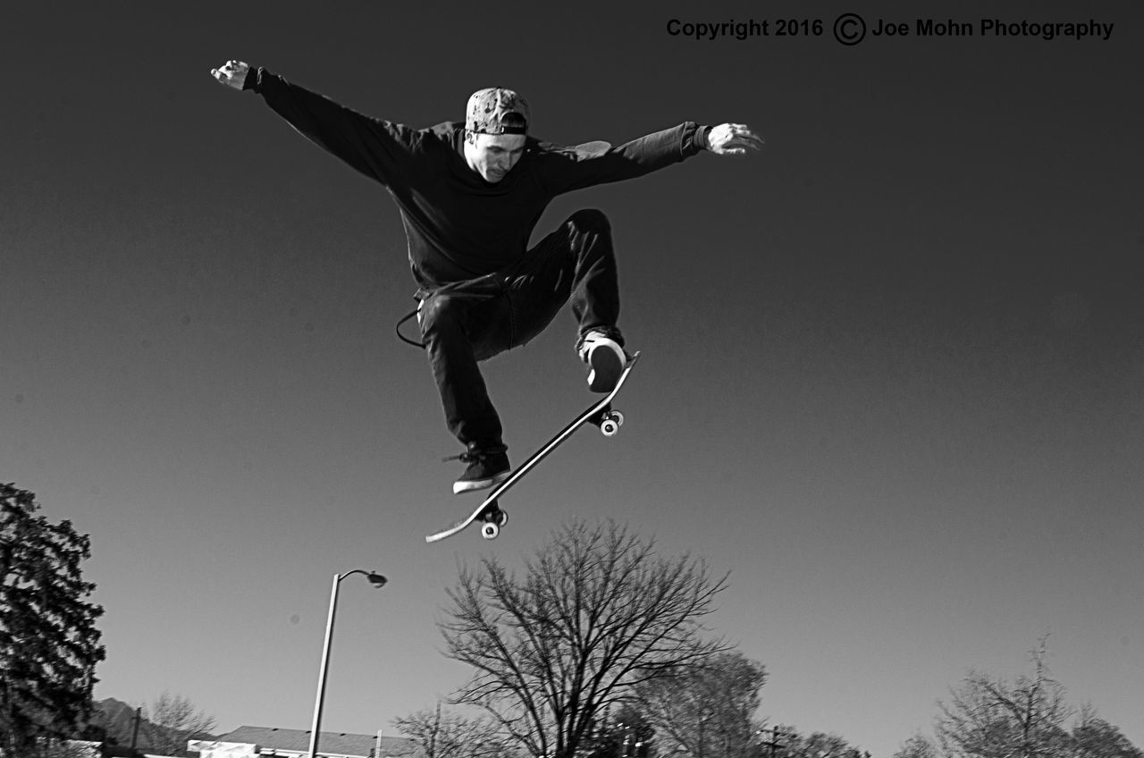 lifestyles, leisure activity, mid-air, skill, full length, jumping, vitality, low angle view, fun, motion, risk, enjoyment, extreme sports, clear sky, sport, men, arms outstretched, holding