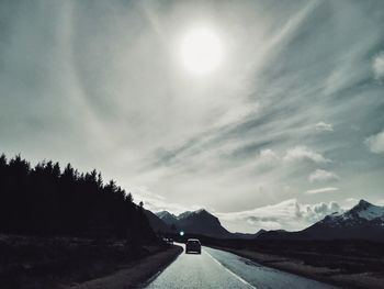 Road amidst snowcapped mountains against sky